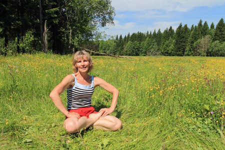 The woman outdoors practices yogaの写真素材