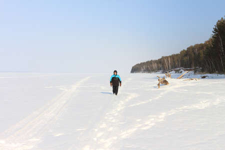 The man goes on a snow field near the coastの写真素材