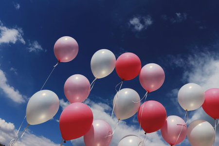 Balloons on threads against the sky and clouds