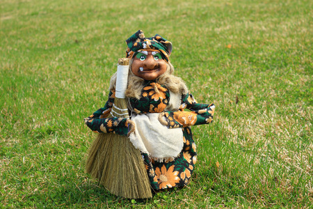 The toy the old kind hag with a sweeper is on a green grassの写真素材