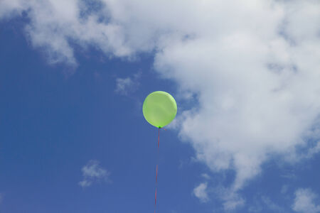 Balloon on a thread against the sky and cloudsの写真素材