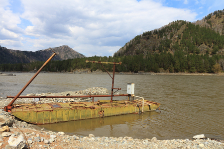 Water pump station on the barge on the river among mountainsの写真素材