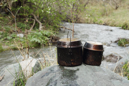 Tourist kettles standing on a stone at the river