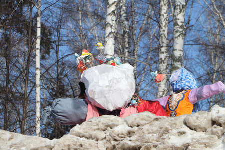 Scarecrow standing on snow among trees in the winterの写真素材