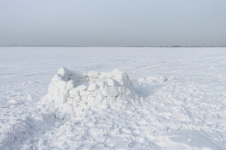 Unfinished snow construction of igloo standing on a snow-covered glade in the winter