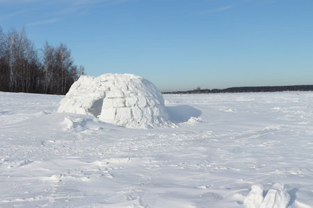 Snow construction of igloo standing on a snow-covered glade in the winter