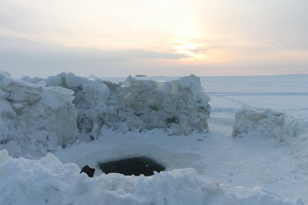 Place for winter bathing on the river at sunset