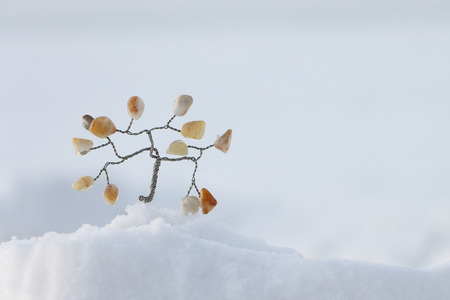 Souvenir a tree of their wire with leaves from selenite standing on snow in the winterの写真素材