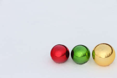 Glass color spheres lying in snow outdoorsの写真素材