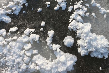 Snow freakish outgrowths on ice of the frozen river, a natural backgroundの写真素材