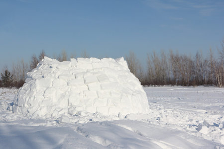 Construction an igloo on a snow glade in the winter