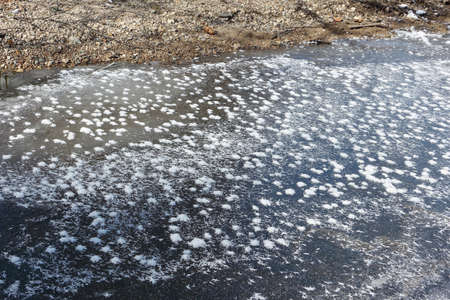 Fancy outgrowths of hoarfrost on ice of the thawing river in the spring, a natural backgroundの写真素材