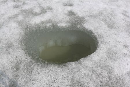 Hole for subglacial fishing on a river surfaceの写真素材