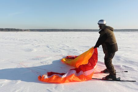 Man spreading kite on snow in winter, Ob Reservoir, Novosibirsk, Russiaの写真素材