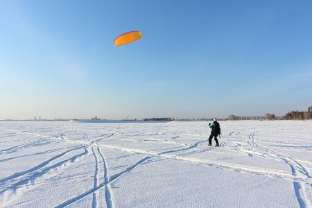 Man is engaged in snowkiting on a frozen reservoir, Novosibirsk, Russiaの写真素材