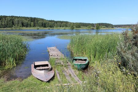 Boats at the mooring bridge on the water, Karakan River, Novosibirsk region, Russiaの写真素材