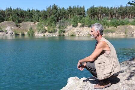 Man sitting on the shore of a lake, Marmara Lake, Novosibirsk region, Russiaの写真素材