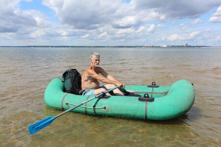 Man walking on a river in an inflatable boat , Ob Reservoir, Novosibirsk, Russiaの写真素材