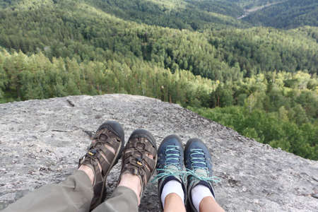 Male and female legs in trekking shoes on the top of the mountain, Altai Mountains, Belokurikha City, Russiaの写真素材