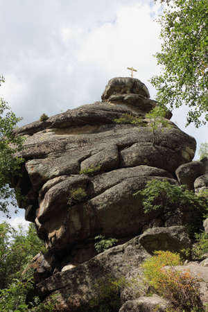 Rock with an Orthodox cross on the top of Mount Tserkovka, Altai Mountains, Belokurikha city, Russiaの写真素材