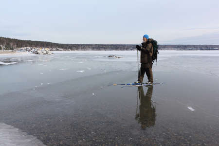Man with a backpack is skiing on the ice of the frozen river, Ob Reservoir, Novosibirsk, Russiaの写真素材