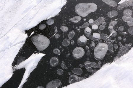 Bubbles under ice, formation of ice on the river, a natural background