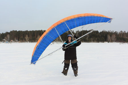 Man training with a kite on a frozen river in winter, Ob reservoir, Novosibirsk, Russiaの写真素材