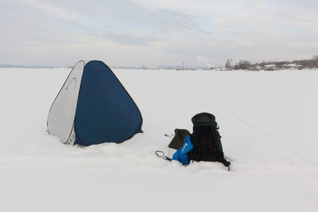 Tent for winter fishing on a frozen river, Kama Reservoir, Perm city, Russia