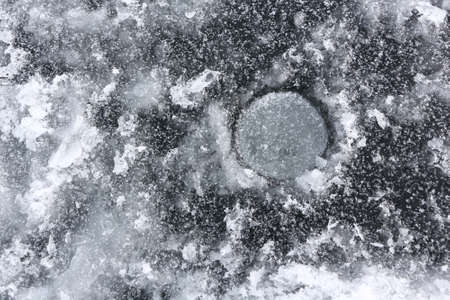 Ice fishing hole on the surface of the river in winter, Ob Reservoir, Novosibirsk, Russiaの写真素材