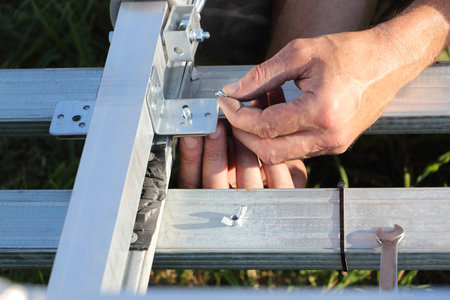 Male hands put a washer on a bolt, fragment of the catamaran bridgeの写真素材