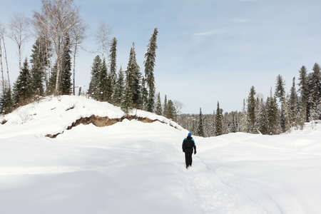 Man walking along a snowy trail from Mount Tulun-Tuu, Altai Republic, Russiaの写真素材