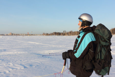 Man training with a kite on a frozen river in winter, Ob reservoir, Novosibirsk, Russiaの写真素材