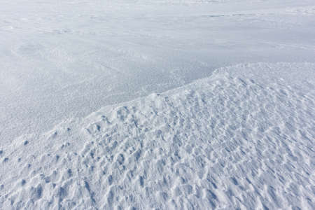 Relief snow surface of a frozen river in winterの写真素材