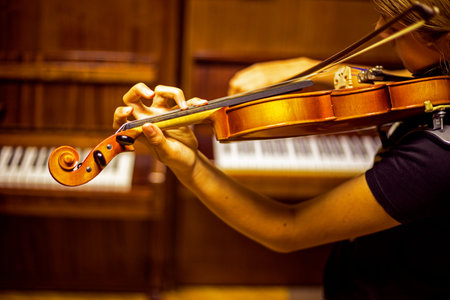 blurry left hand of a young violinist presses the strings on the violin neck, horizontalの写真素材