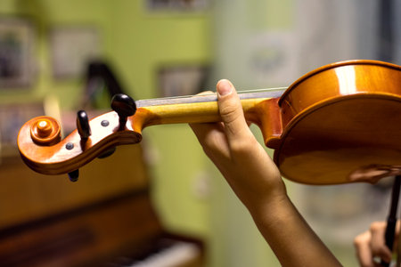 blurry left hand of a young violinist presses the strings on the violin neck, horizontalの写真素材