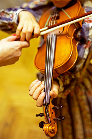 blurry left hand of a young violinist presses the strings on the violin neck, horizontalの写真素材