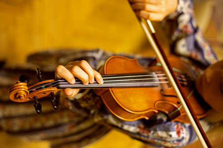 blurry left hand of a young violinist presses the strings on the violin neck, horizontalの写真素材