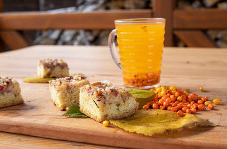 good morning, hot tea with a cake, sea buckthorn berries and blackberry leaves, horizontalの写真素材