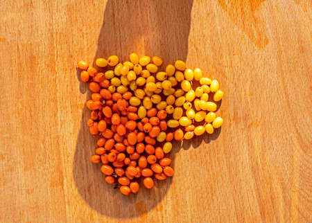 good morning heart with sea buckthorn on a wooden surface, horizontalの写真素材