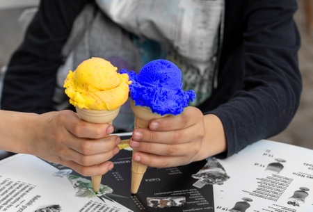 pink ice cream in a waffle cone on the background of the cityscape, holidaysの写真素材