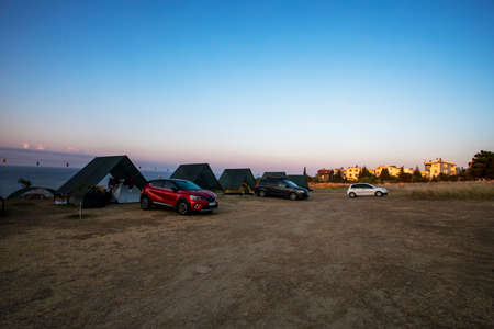 campsite with tents and cars on the mediterranean sea at dawn when the sun rises. family holidaysの写真素材