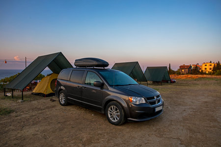 campsite with tents and cars on the mediterranean sea at dawn when the sun rises. family holidaysの写真素材