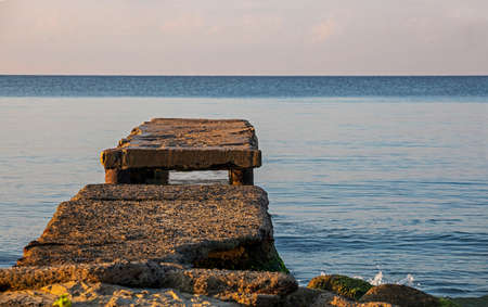 stone jetty in the early sunny morning on the marble sea. family holidays.の写真素材