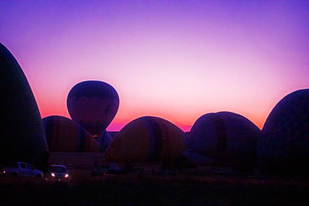 lying and rising balloons that inflate with gas before the flight before dawn in Cappadociaの写真素材