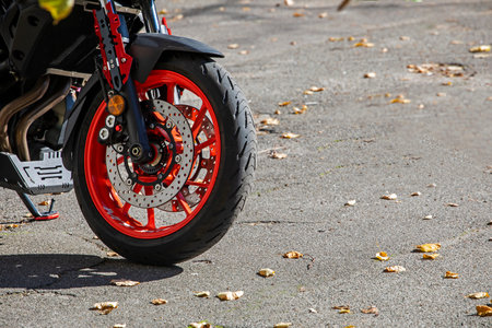 red motorcycle wheel parked on asphalt, horizontal