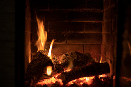 burning fire in a stone fireplace with wood, cozy homeの写真素材