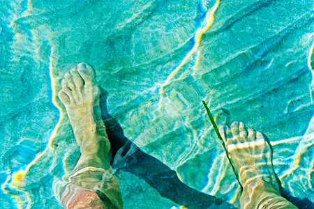 a pair of feet of sea water on a shallow beach in the Soronic Gulfの写真素材