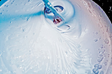 stir white paint with a violet pigment for painting wallsの写真素材