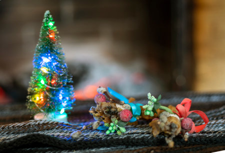 Christmas tree with lights and candles on the background of a stone fireplace with wood. cozy house waiting for christmas horizontalの写真素材