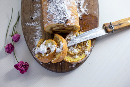 freshly baked two slice of apple roll with crumbs and a rose, family breakfast, horizontal